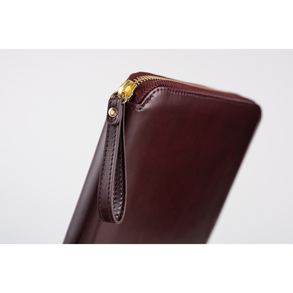 Close-up of the Amarone leather A5 Cousin book cover, showing its gold zipper and stitched pull tab.
