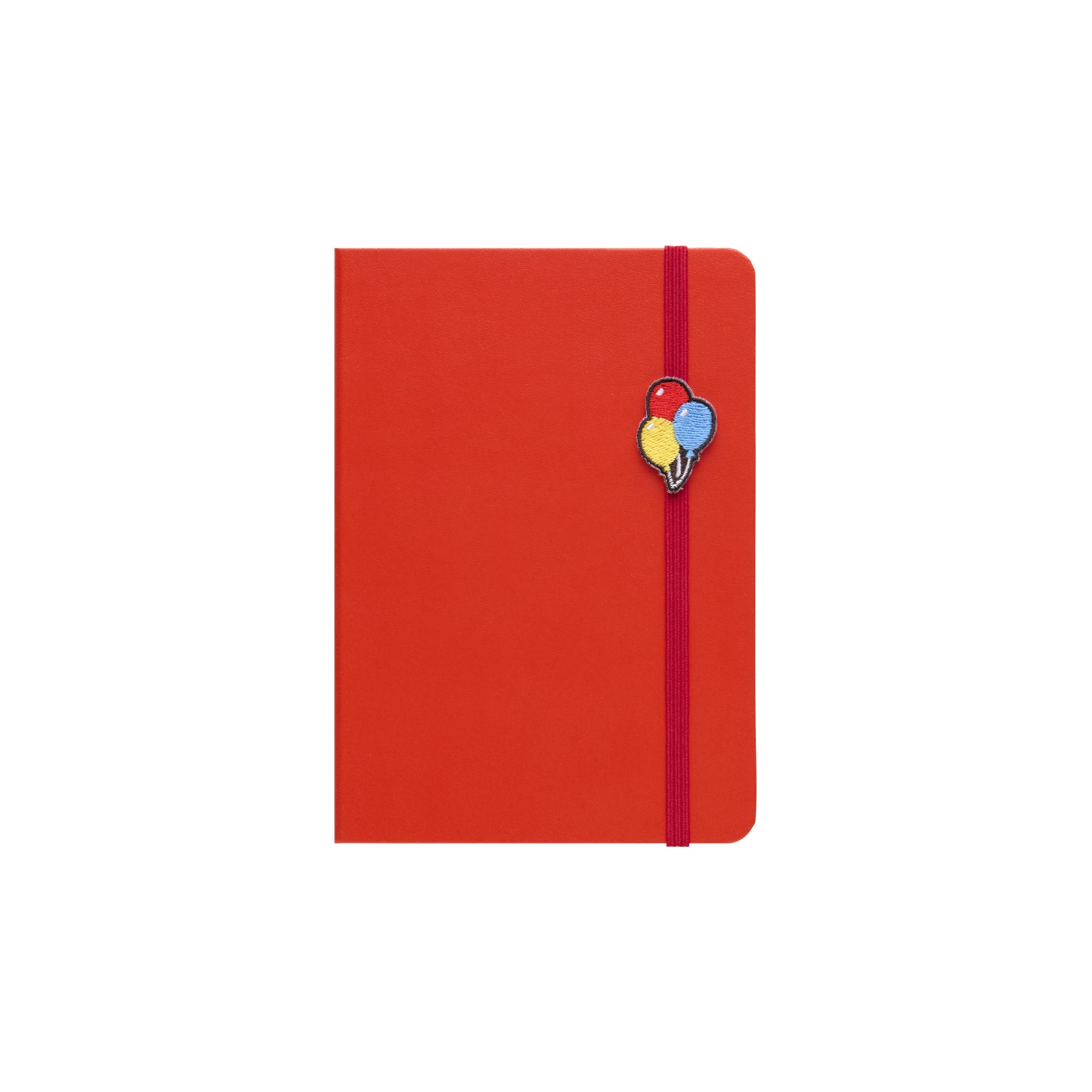 Red hardcover A6 planner with elastic band and embroidered balloon charm on the front cover.