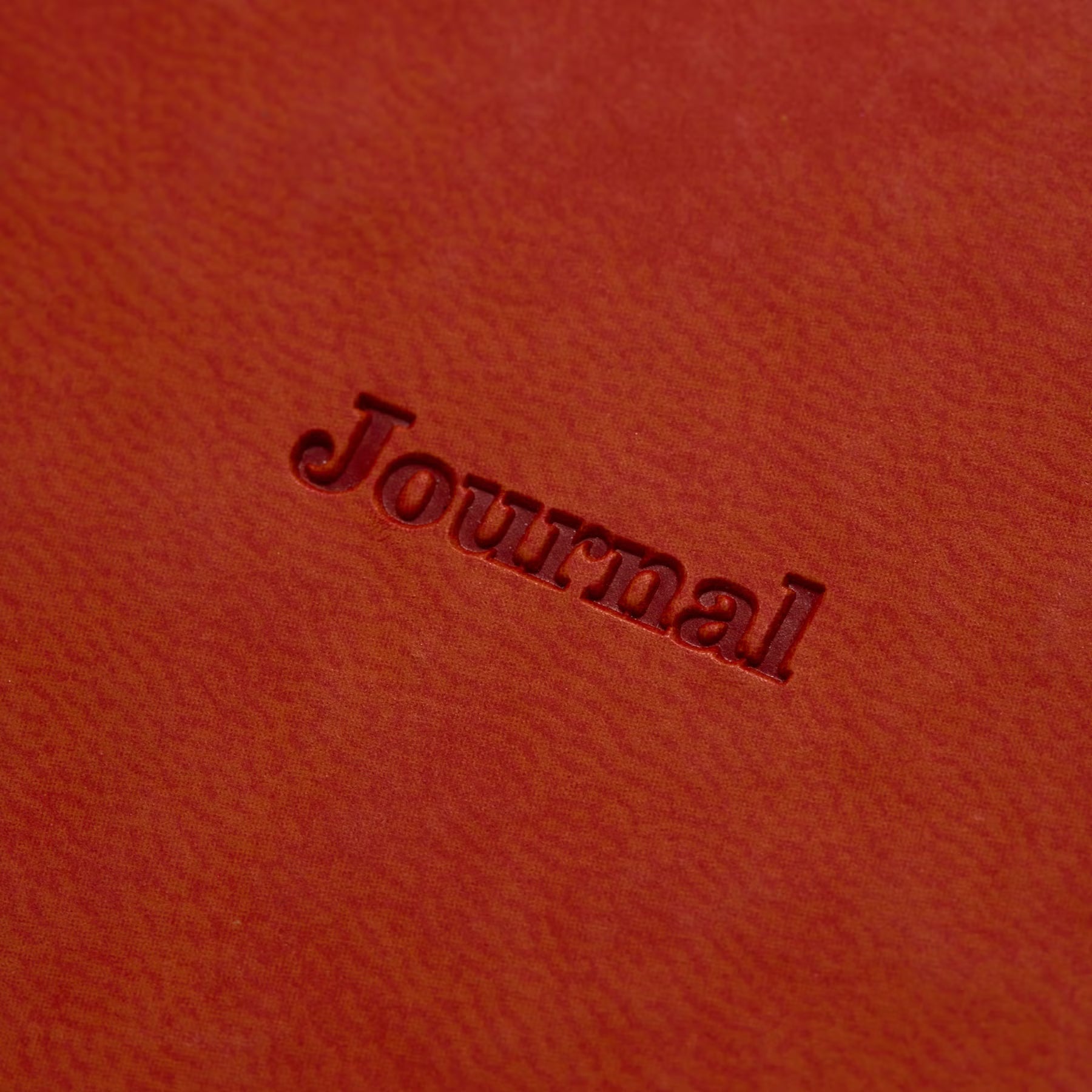 Close-up of "Journal" debossed into the Red Brown velour-like cover of the 2027 weekly planner.