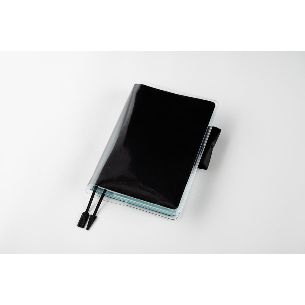 Hobonichi A6 planner in a Black cover under a clear protective sleeve, with two black bookmark tabs