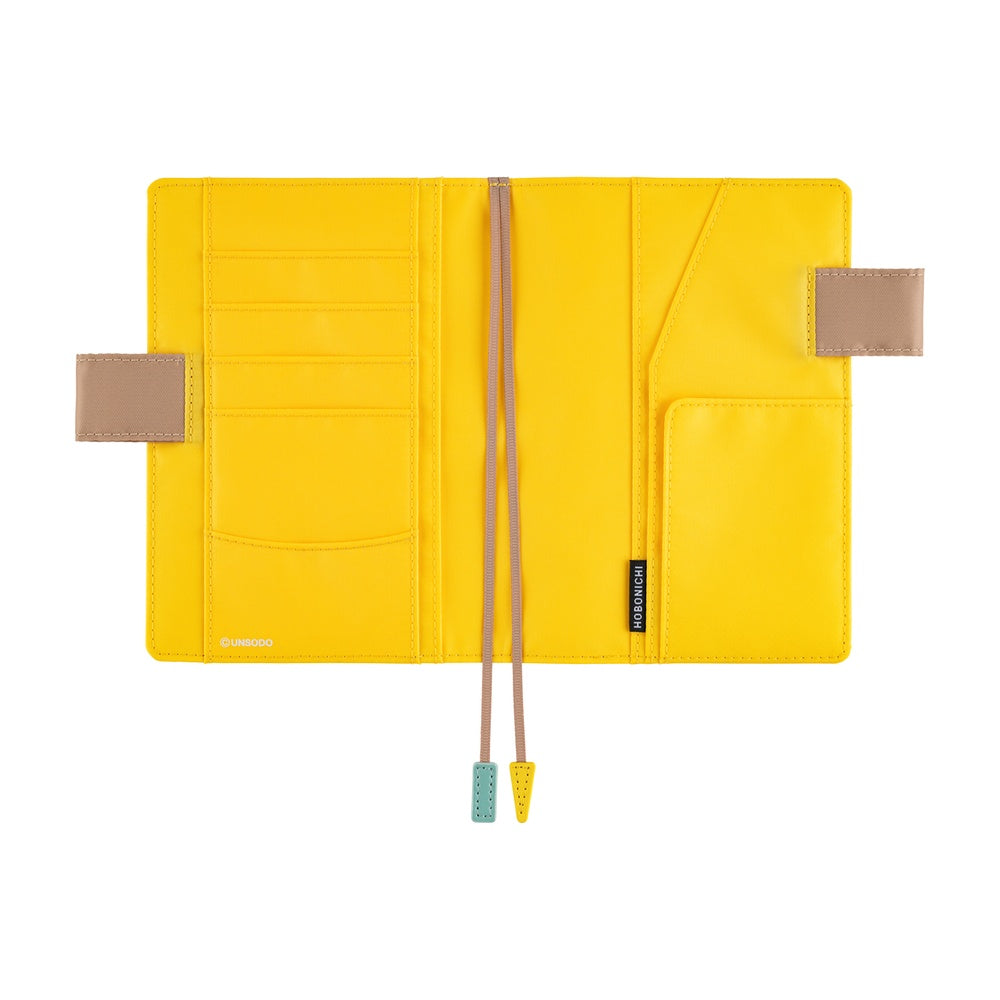 Hobonichi A6 book cover opened flat, yellow interior with card slots, pockets and two bookmark ribbons.
