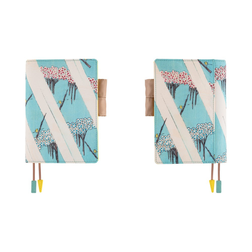 Front and back views of a Hobonichi A6 book cover in light blue floral print with pen loop and bookmarks