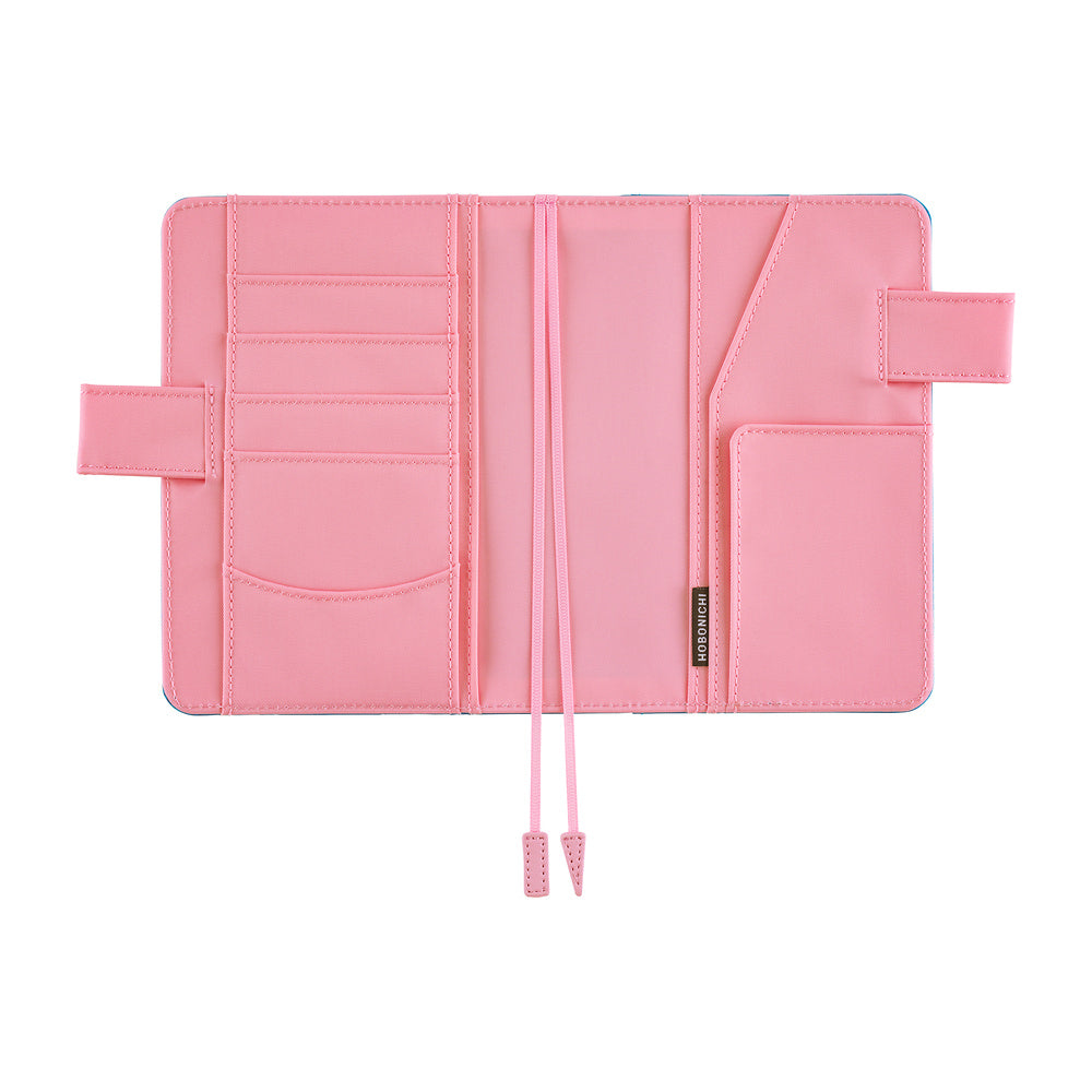 Hobonichi A6 book cover opened flat, showing pink interior with card slots, pockets and bookmarks.