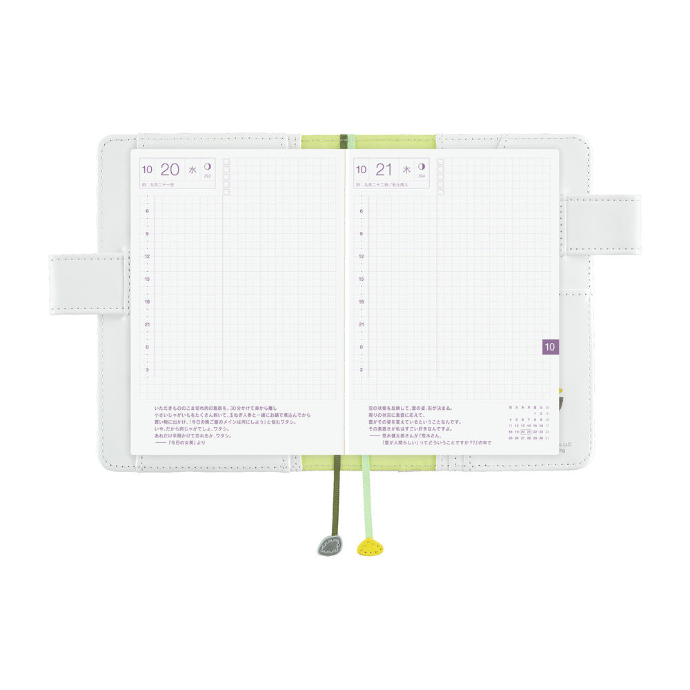 White Hobonichi A6 book cover open flat with grid daily pages, side pen loops and two bookmark ribbons.