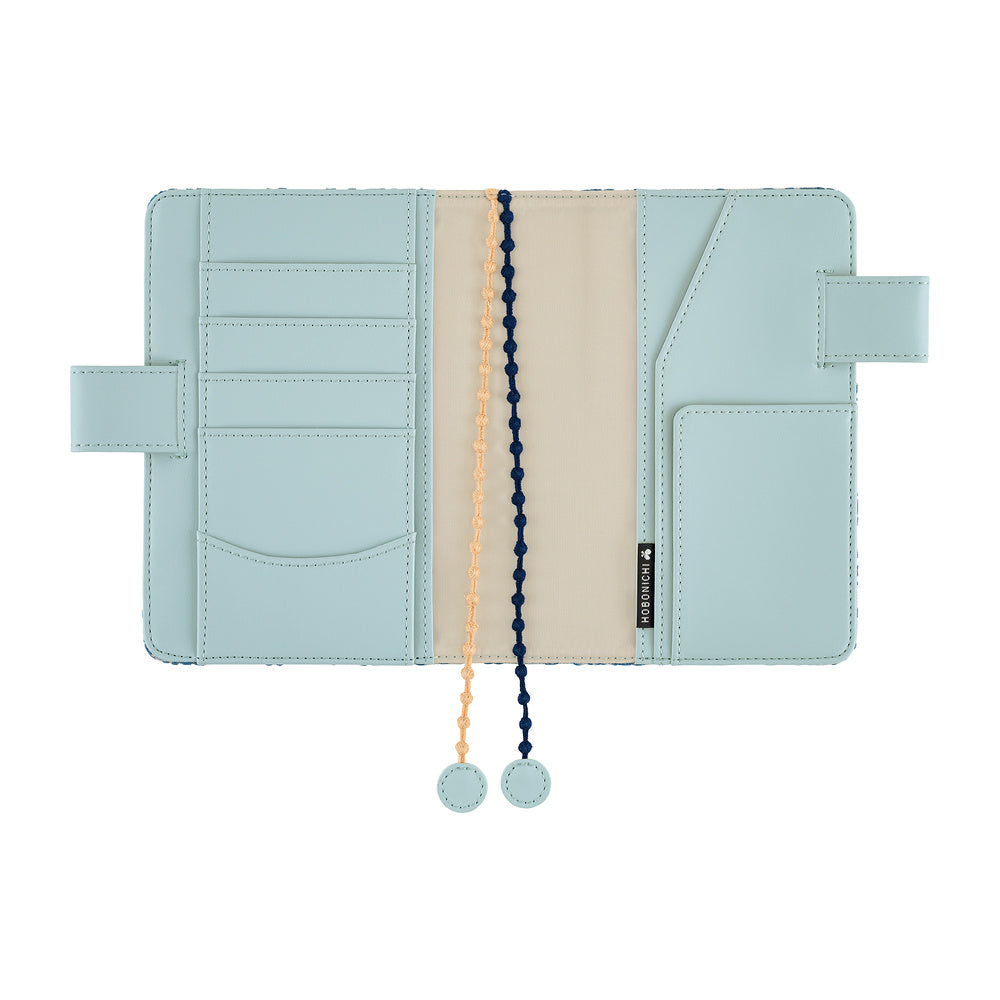 Hobonichi A6 book cover opened flat, showing Blue interior with card slots, pockets and two bookmark cords.