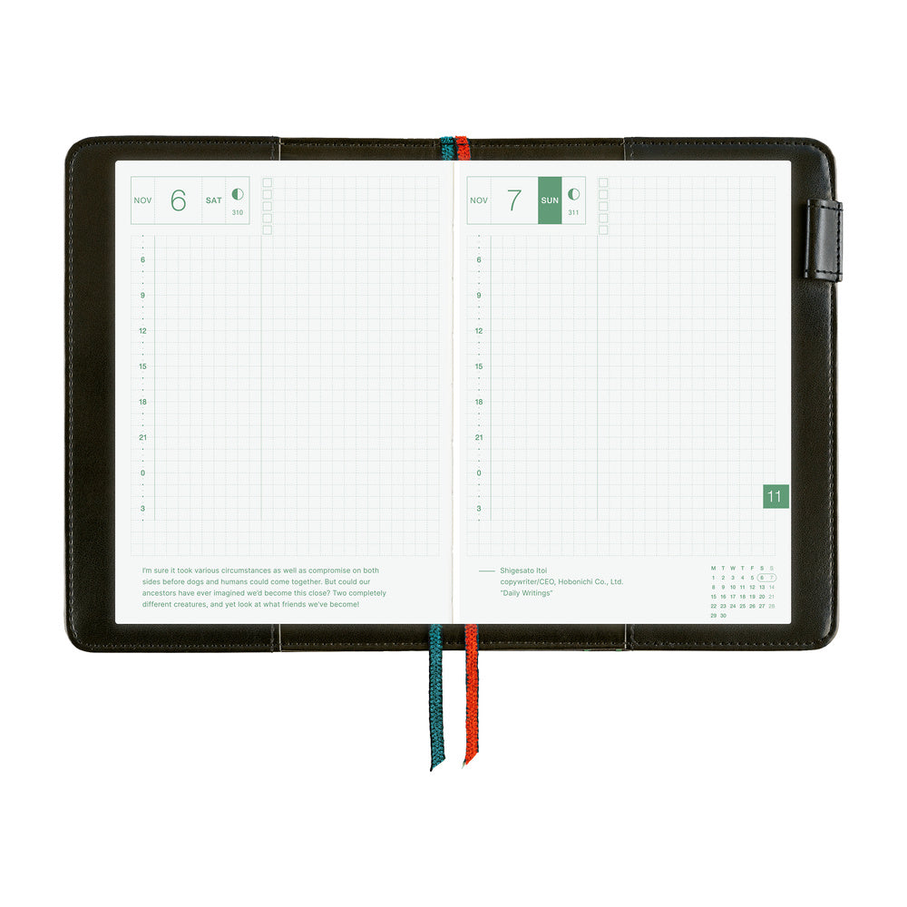Hobonichi A6 book cover in Navy, open flat to grid-ruled daily pages with teal and red ribbon bookmarks.