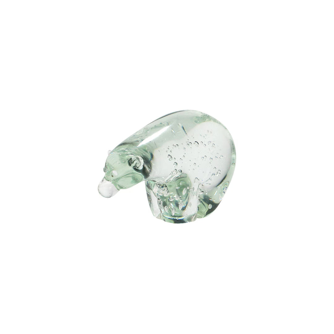 Clear green-tinged glass polar bear figurine with air bubbles inside and a white nose, on white background