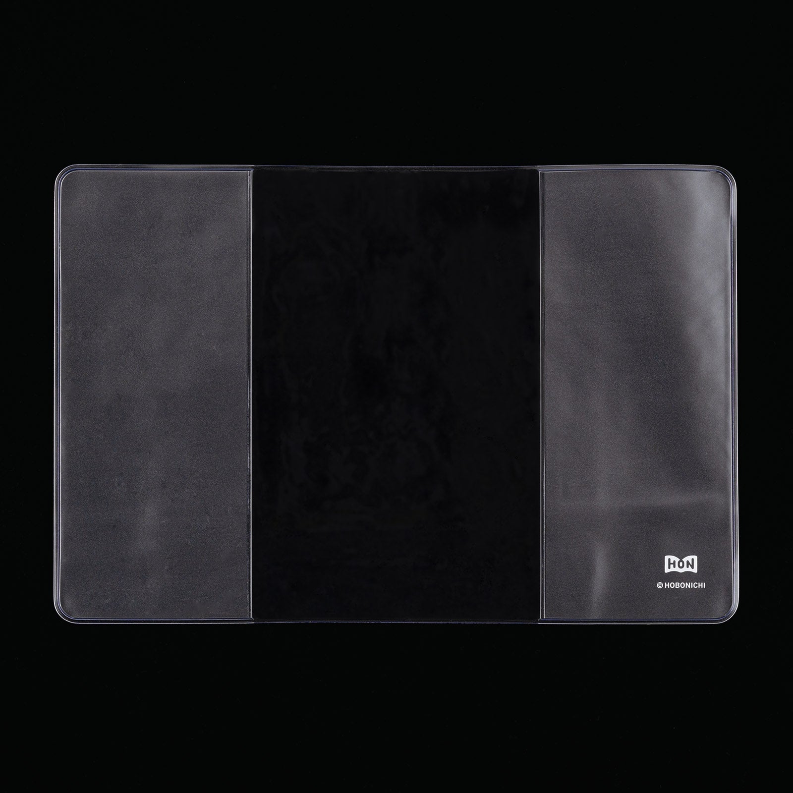 Hobonichi clear cover for the Hon A6 planner, laid flat with side flaps and a small corner logo.