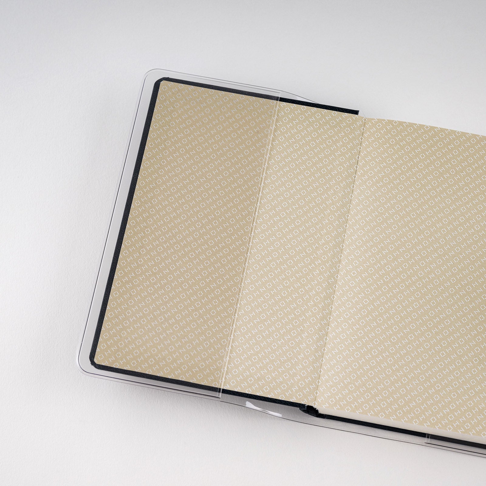 Hobonichi clear cover on an open Hon A6 planner, showing the patterned endpaper beneath the transparent film.