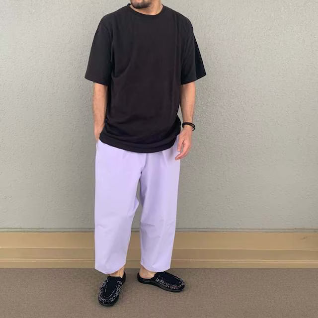 Person wearing Voiry Sunday Pants in Lavender with a black tee and dark slip-on shoes, full-length view