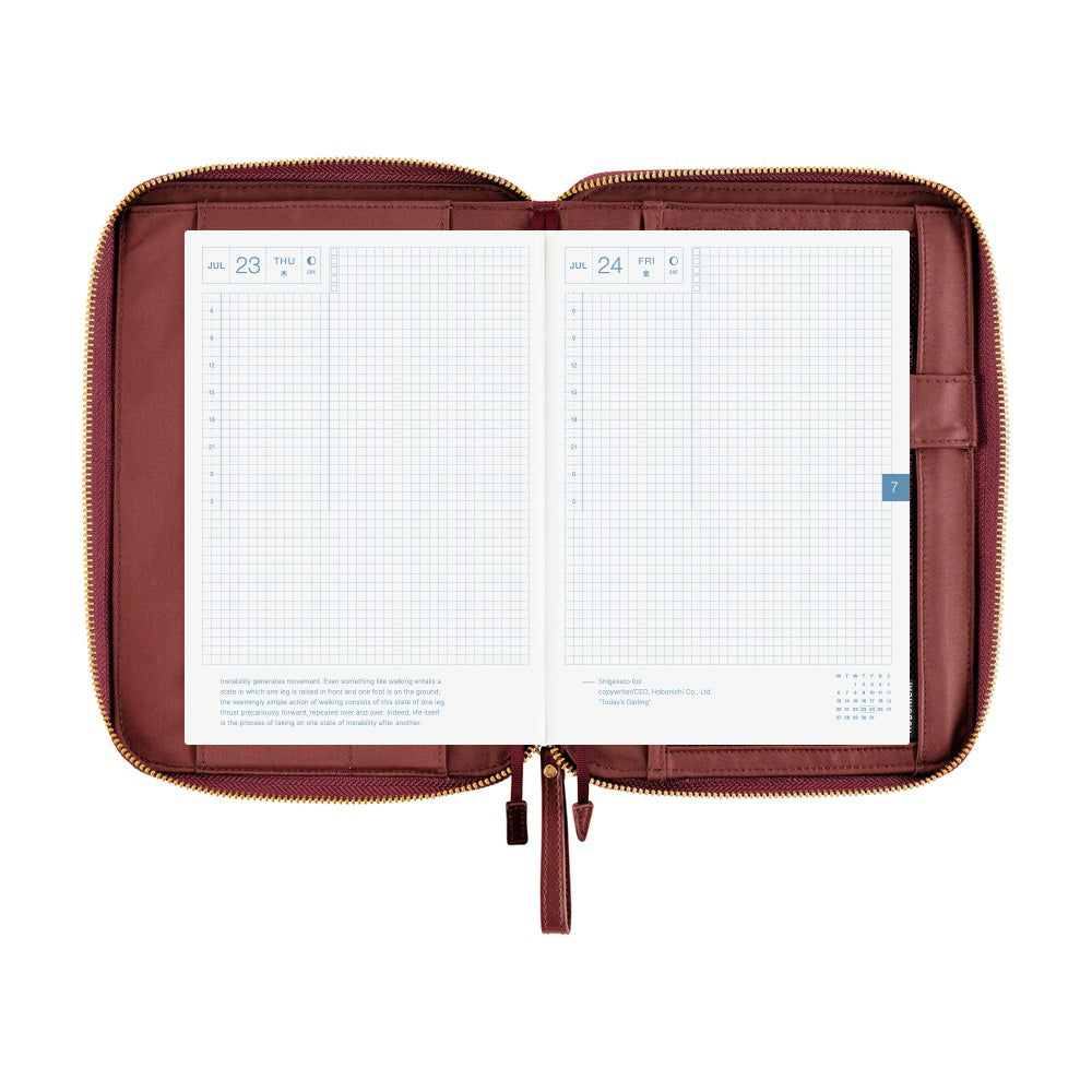 Hobonichi A5 Cousin zippered cover in Amarone, open flat to show grid daily pages and inner pockets
