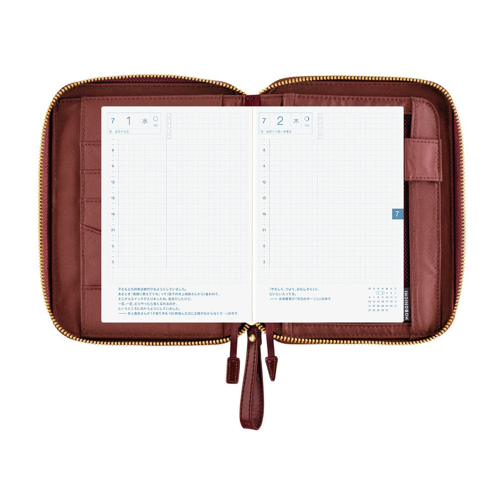 Hobonichi A6 zip cover in Amarone, open flat to show grid daily pages, card slots and pen holder.