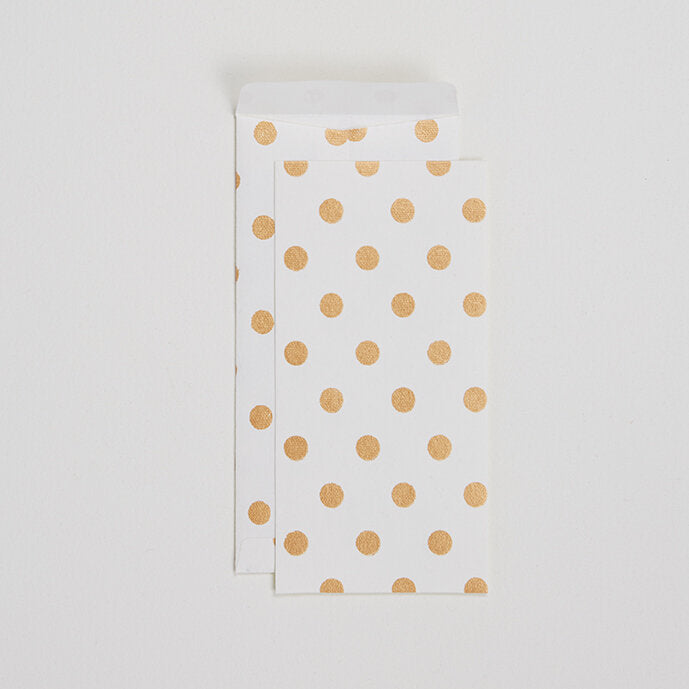 Two white envelopes with gold polka dot print, one overlapping the other on a plain background.