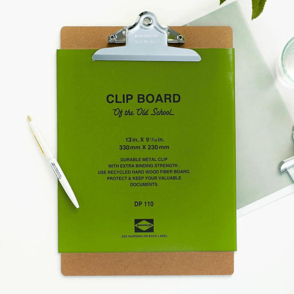 Penco wood fiber clipboard with silver metal clip, green product label attached, beside a white pen.