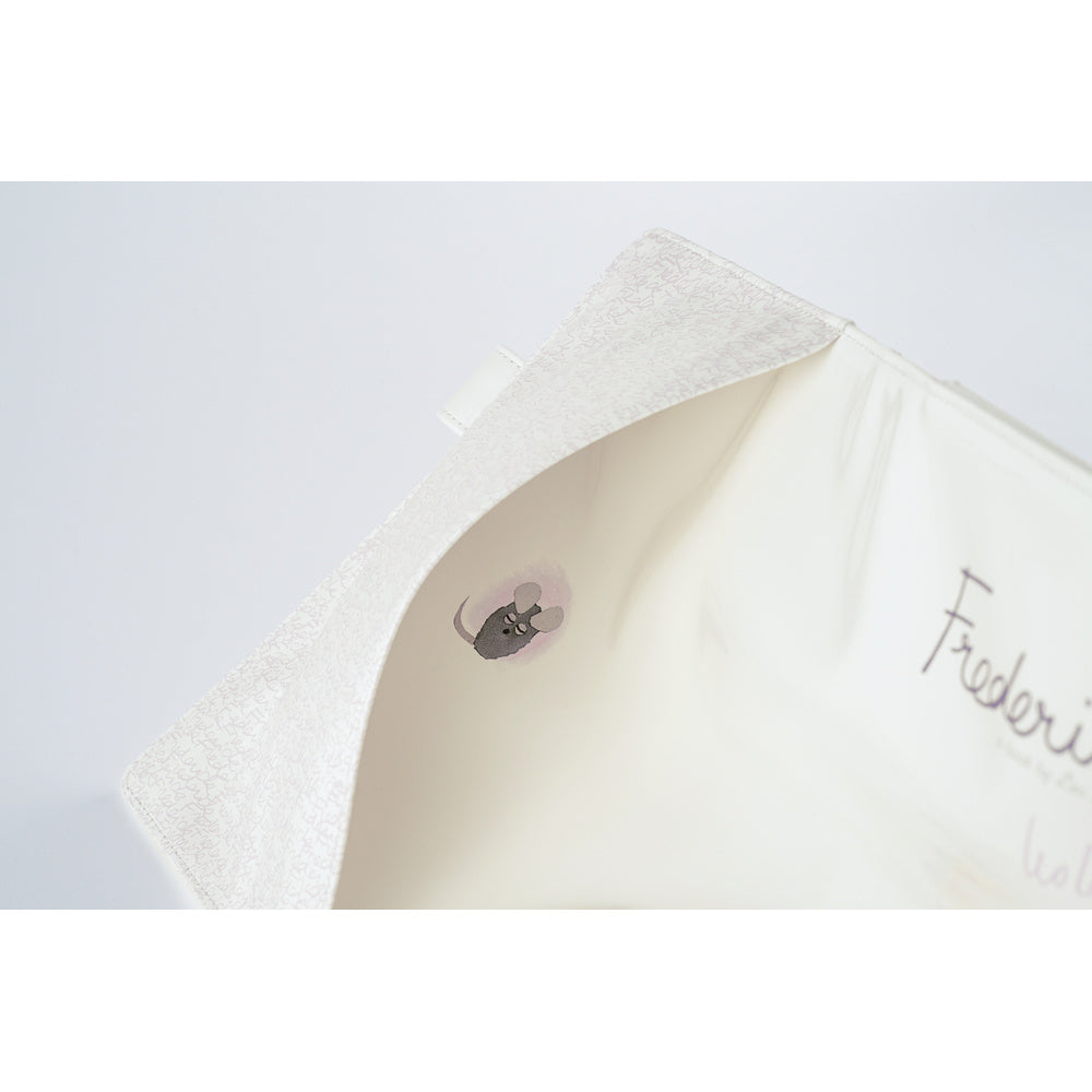 Close-up of the open White Hobonichi A5 Cousin cover showing a small mouse illustration and script lettering inside.