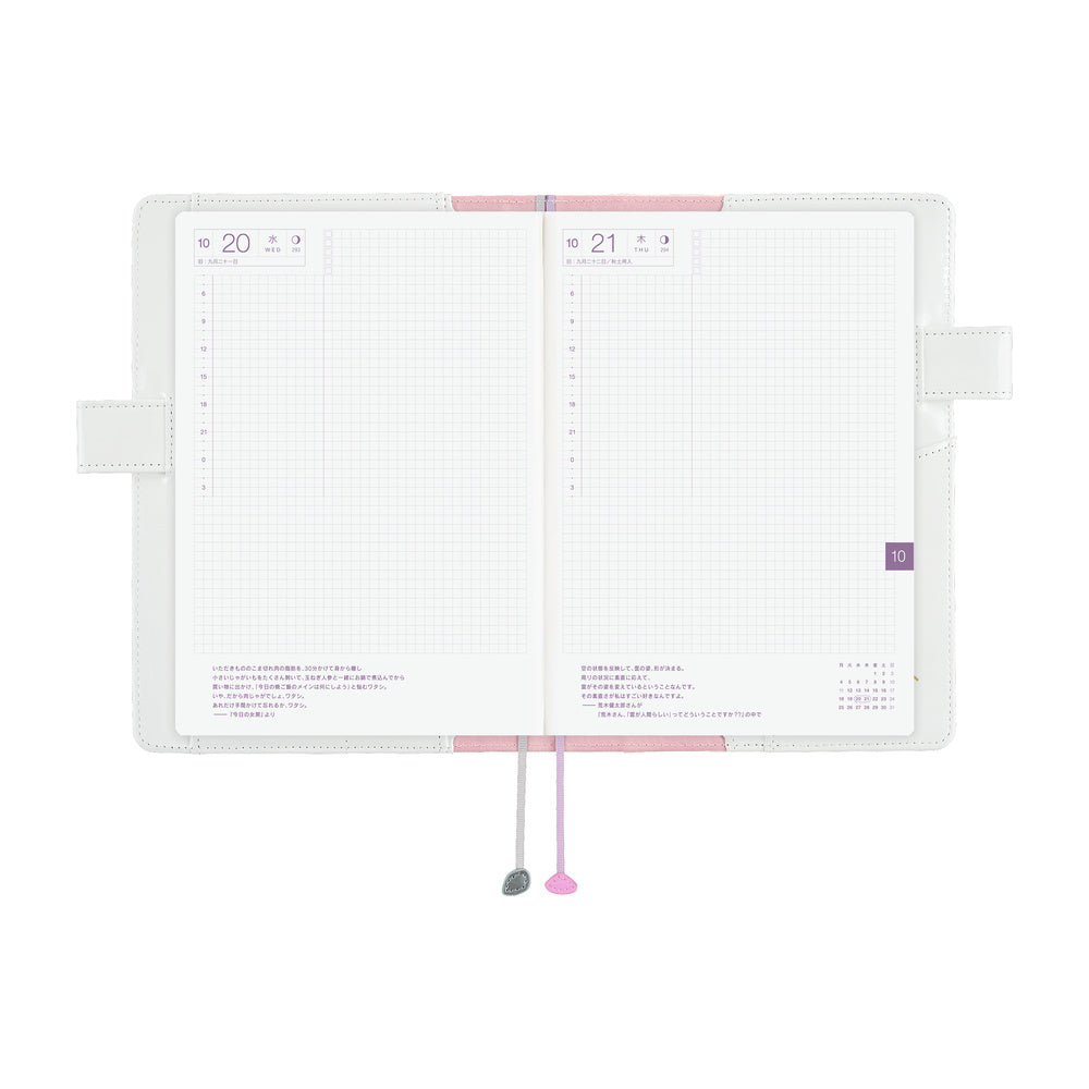 Hobonichi A5 Cousin planner open to grid daily pages, held in a White cover with two ribbon bookmarks.