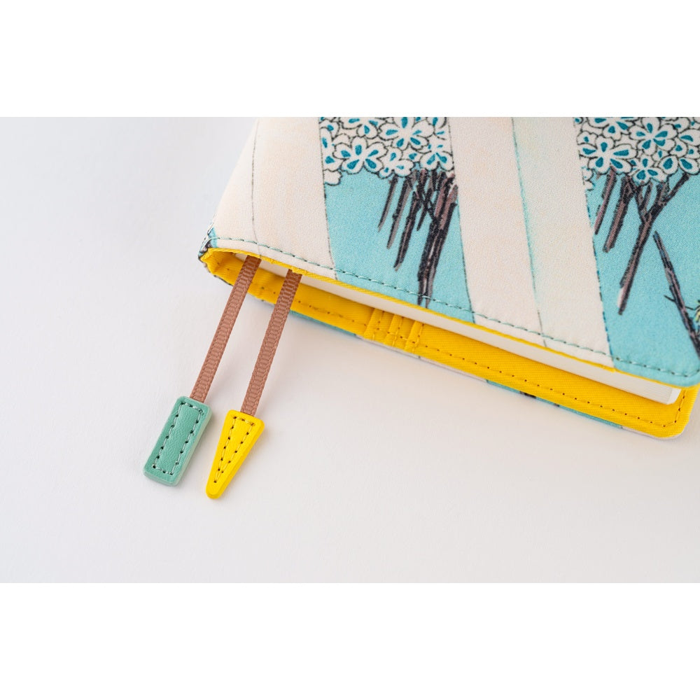 Close-up of the A6 book cover's yellow interior with two bookmark tabs, one mint and one yellow.
