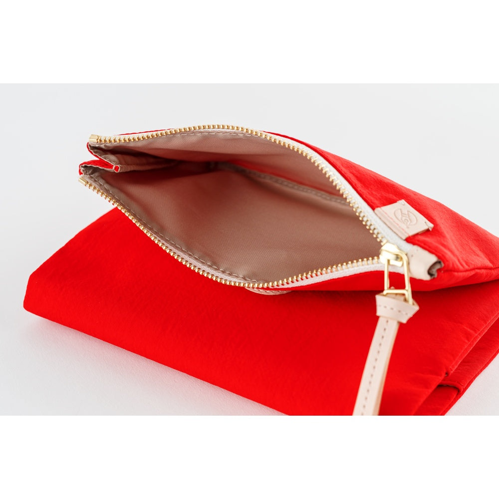Close-up of the open zippered pocket on a Red Hobonichi book cover, showing lining and gold zipper pull.