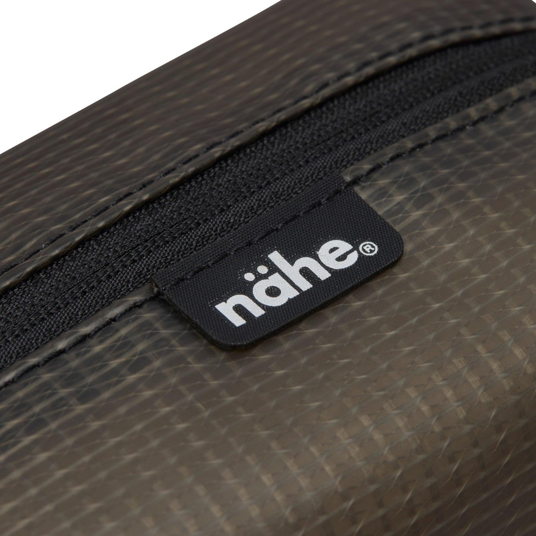 Close-up of the black Nähe label and zipper trim on the Gray semi-transparent grid pouch.