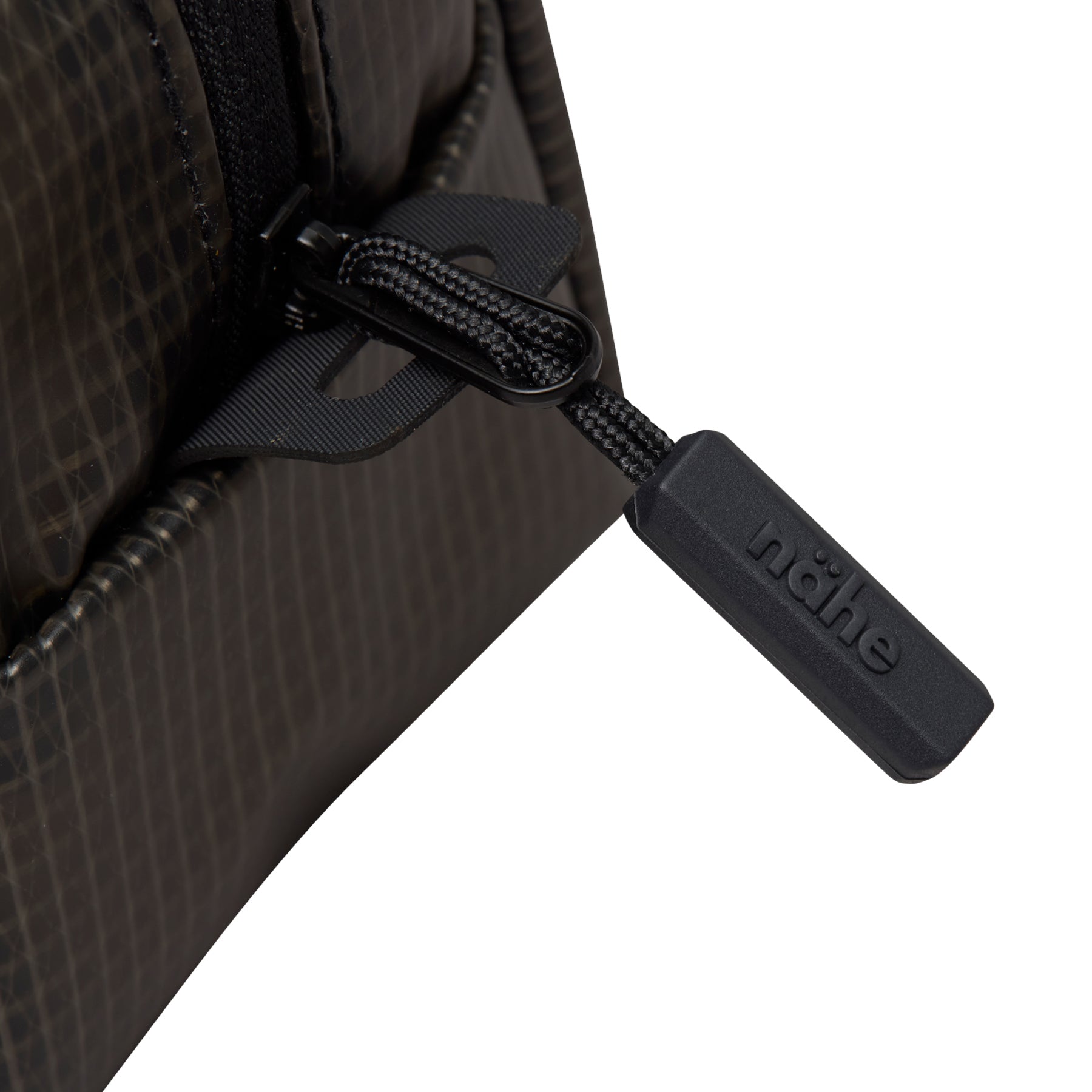 Close-up of the black zipper pull on a Gray grid-patterned Nähe pouch, embossed with the nähe logo.