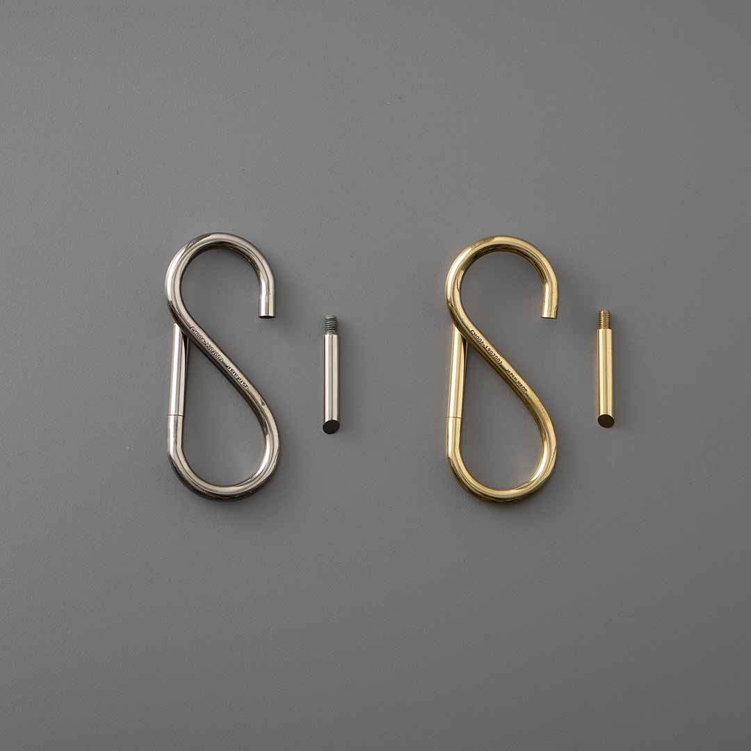 Two S-shaped key rings in Nickel and Brass shown beside their removable screw-in closing pins.