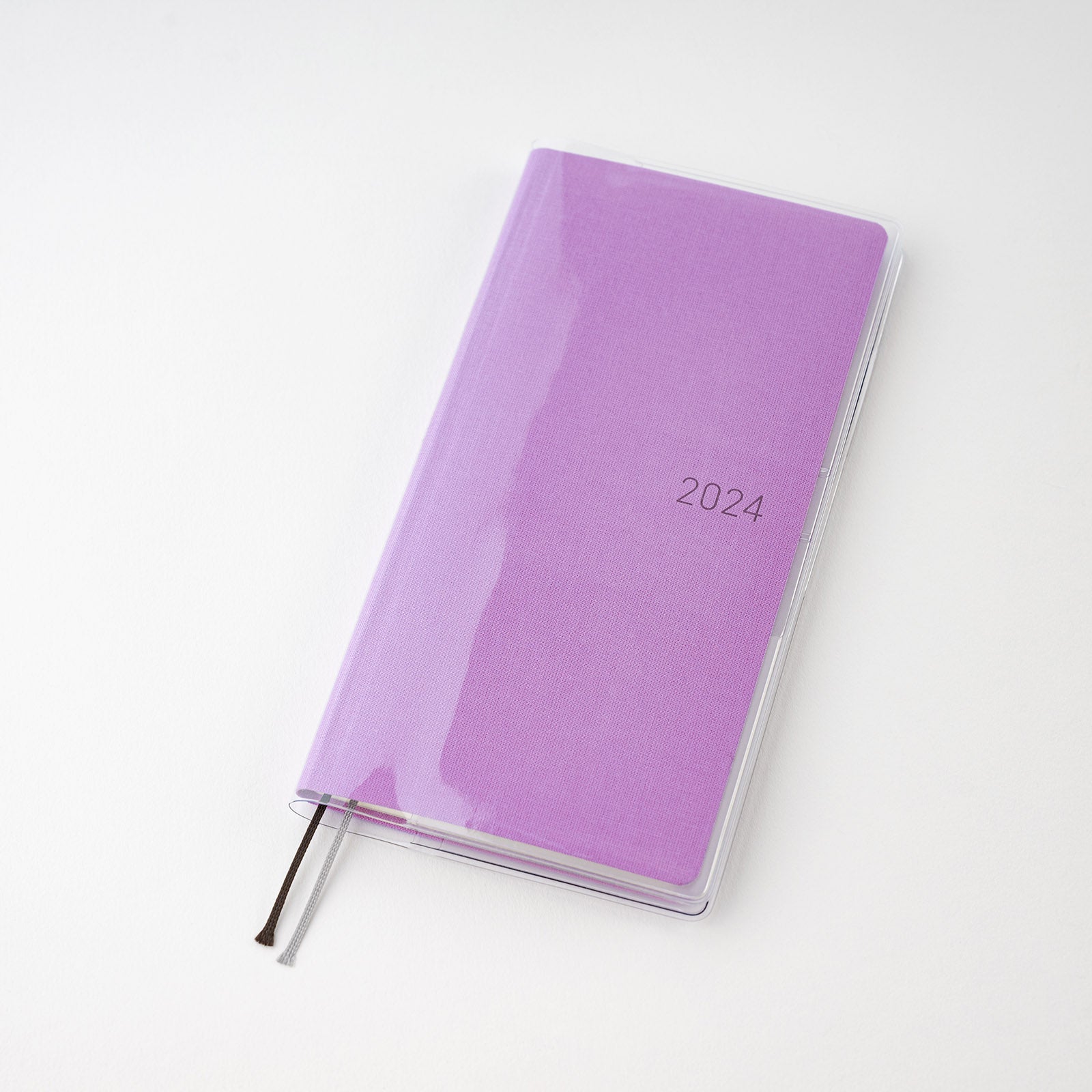 Clear plastic cover fitted over a purple 2024 Hobonichi Techo Weeks planner with two ribbon bookmarks