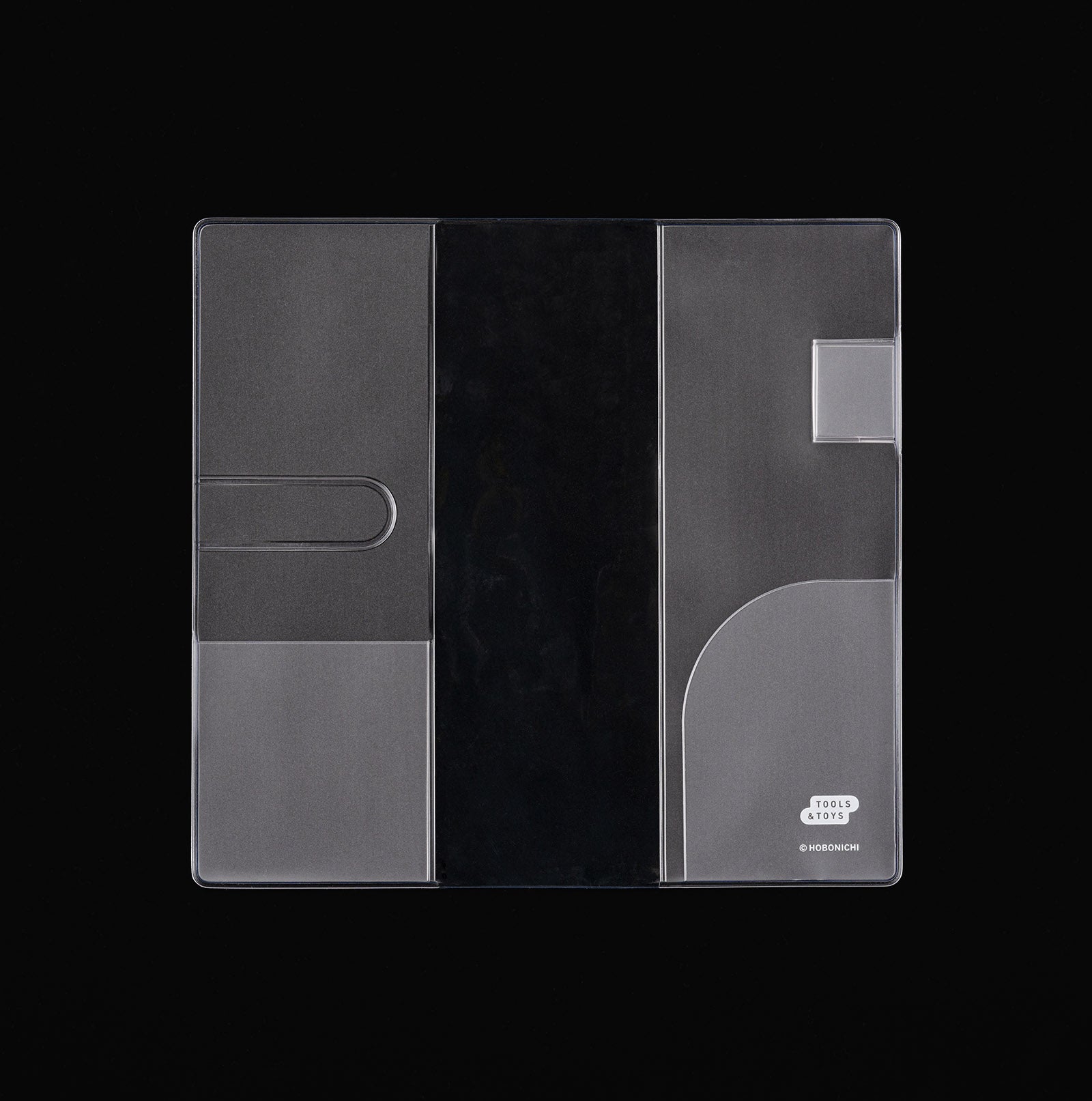 Hobonichi clear PVC cover for Weeks planner, opened flat with inner pockets and pen loop, on black.