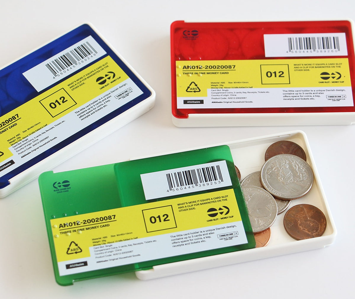Blue, Red and Green card cases with yellow labels, the Green one slid open to reveal coins inside.