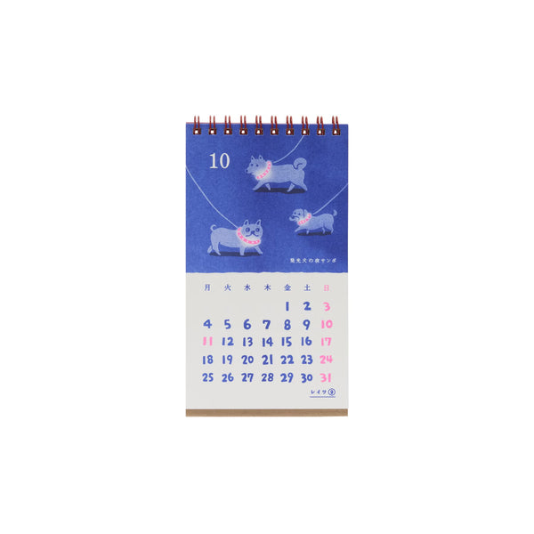 Wire-bound desk calendar open to October, with dogs in pink collars on a blue page above pink and blue dates.