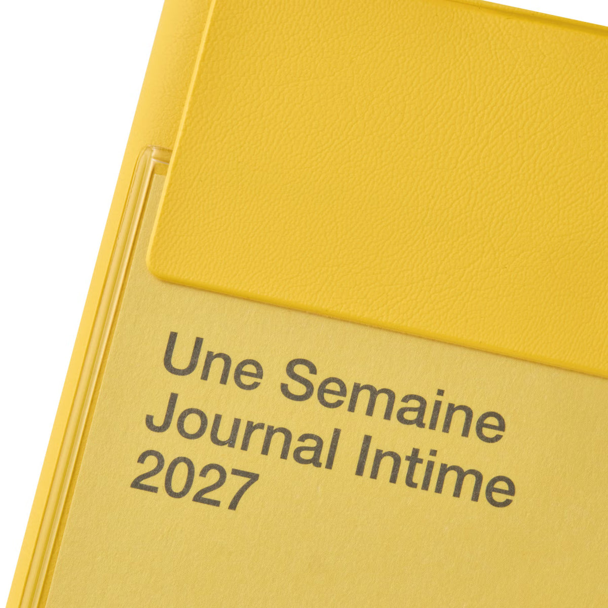 Close-up of the Yellow Iris planner cover showing its clear lidded pocket and "Une Semaine Journal Intime 2027" text.