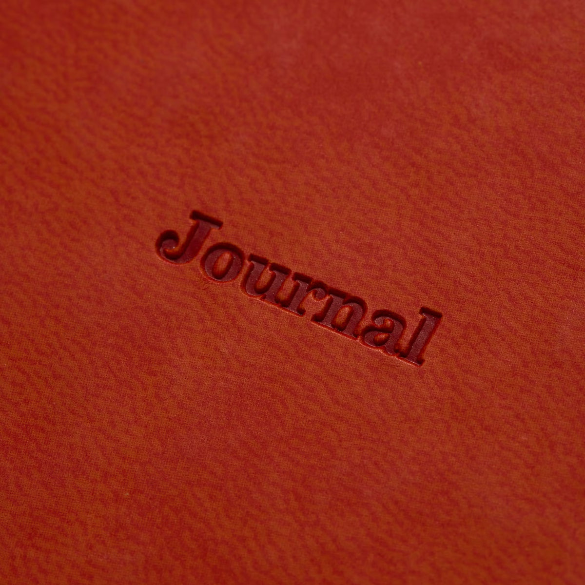 Close-up of "Journal" debossed into the Red Brown velour-like cover of the 2027 weekly planner.