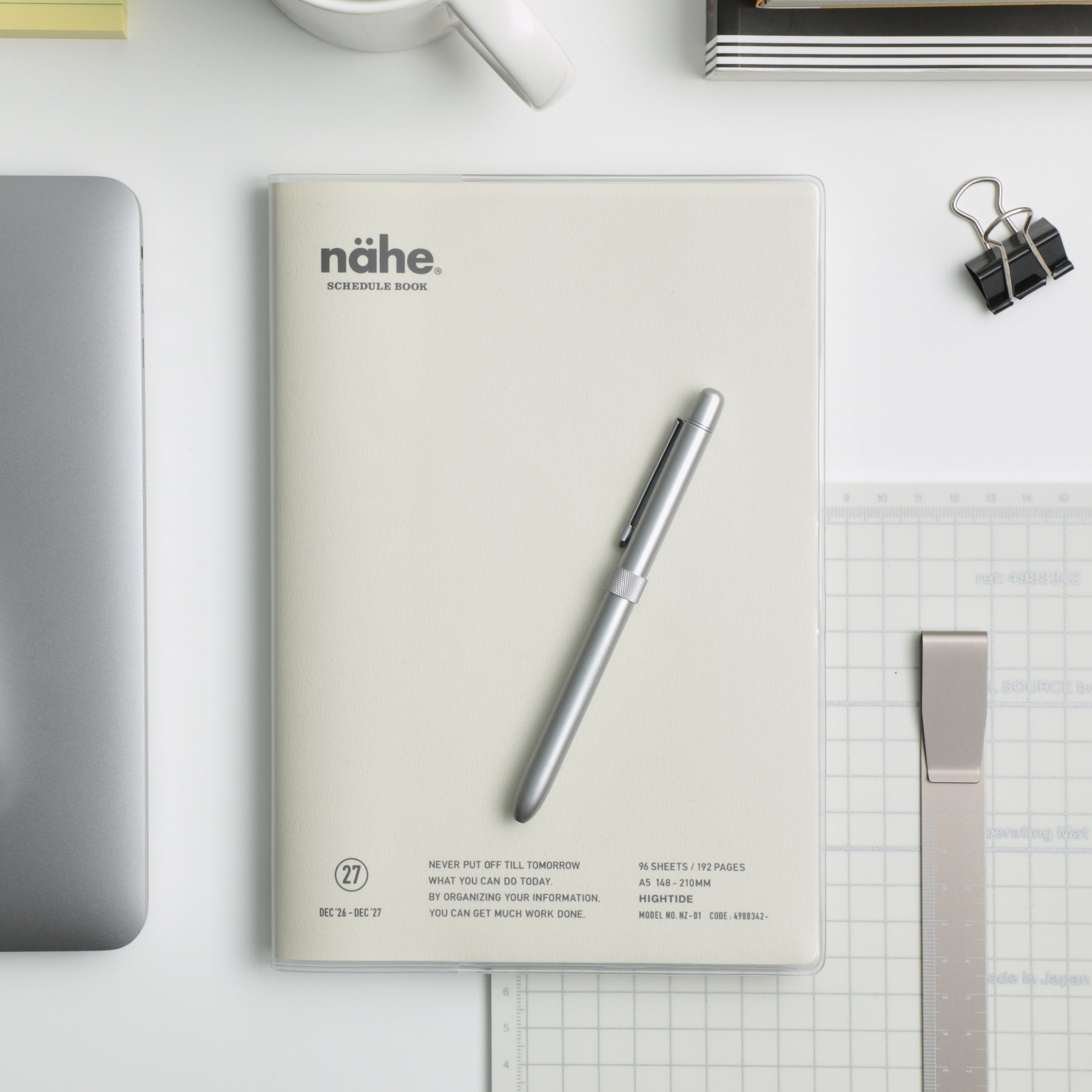 Nähe A5 planner in Ivory with clear cover, shown on a desk with a silver pen, laptop and ruler.