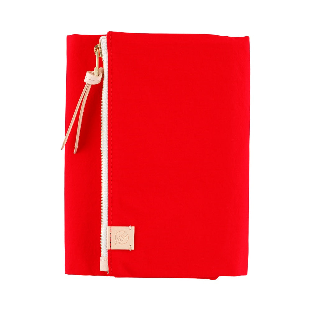 Red Hobonichi A6 book cover with front zip pocket, leather pull tassel and small leather logo tab.