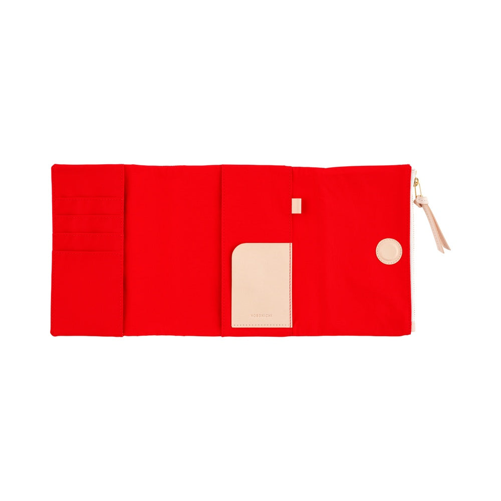 Hobonichi A6 book cover in Red, opened flat to show card slots, pale inner pocket and zip pull.