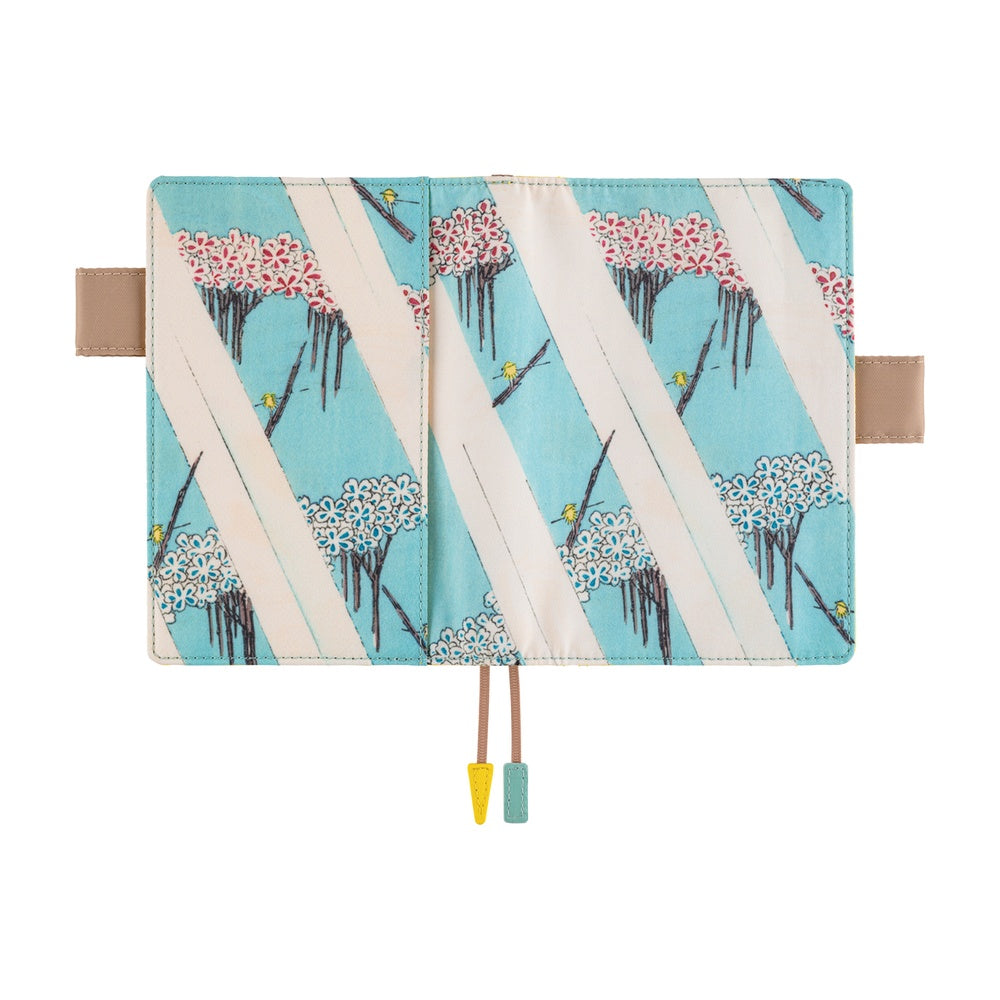 Open A6 book cover printed with cherry blossom trees and boats on turquoise, with two bookmark cords.