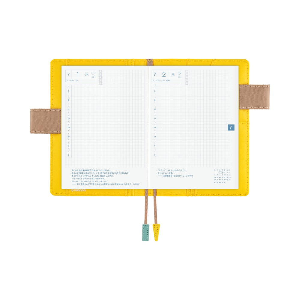 Yellow A6 book cover opened flat with daily grid planner pages, tan side flaps and two bookmark tassels.
