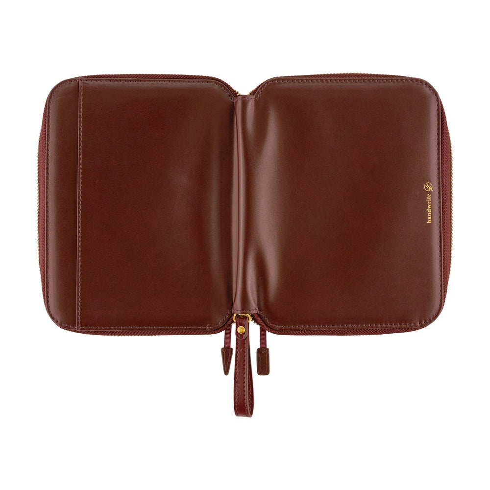 Hobonichi A6 zip planner cover in Amarone, opened flat to show smooth interior and gold zipper pulls