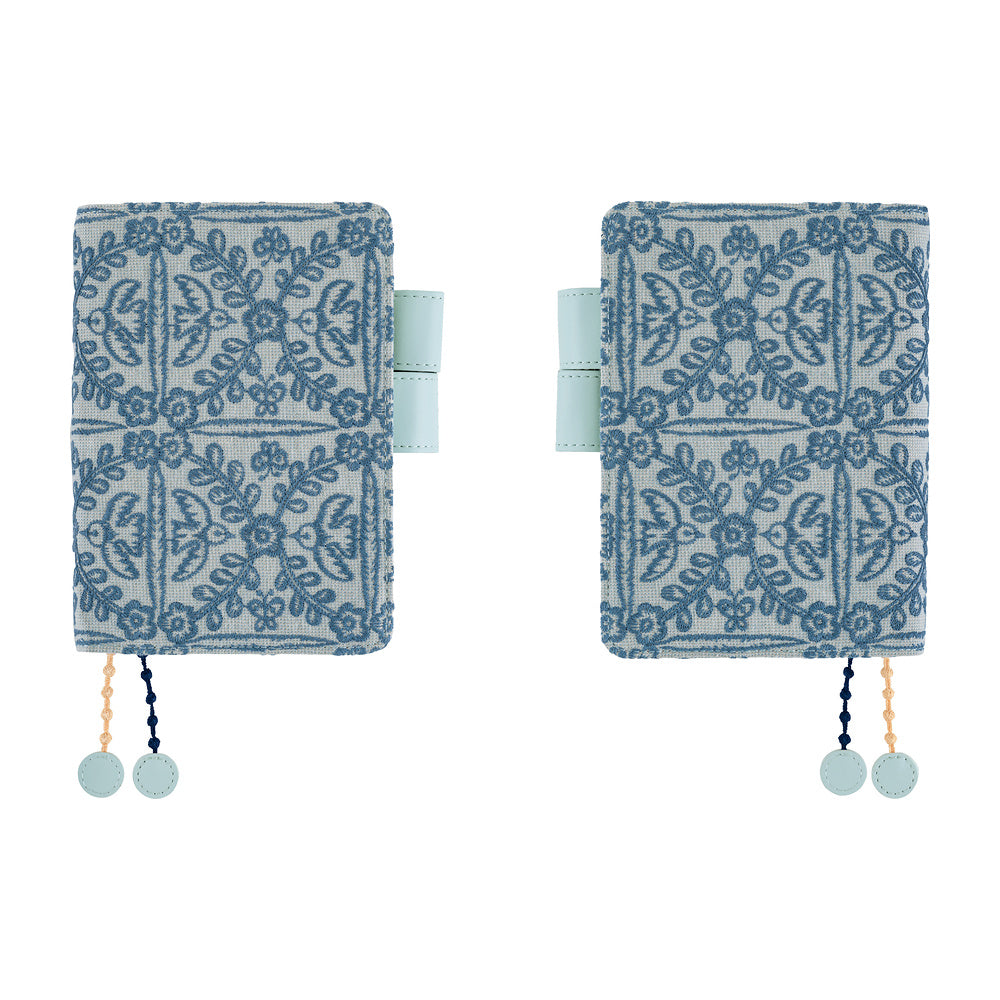 Hobonichi A6 book cover in Blue floral embroidered fabric, shown front and back with pen loop and charms.
