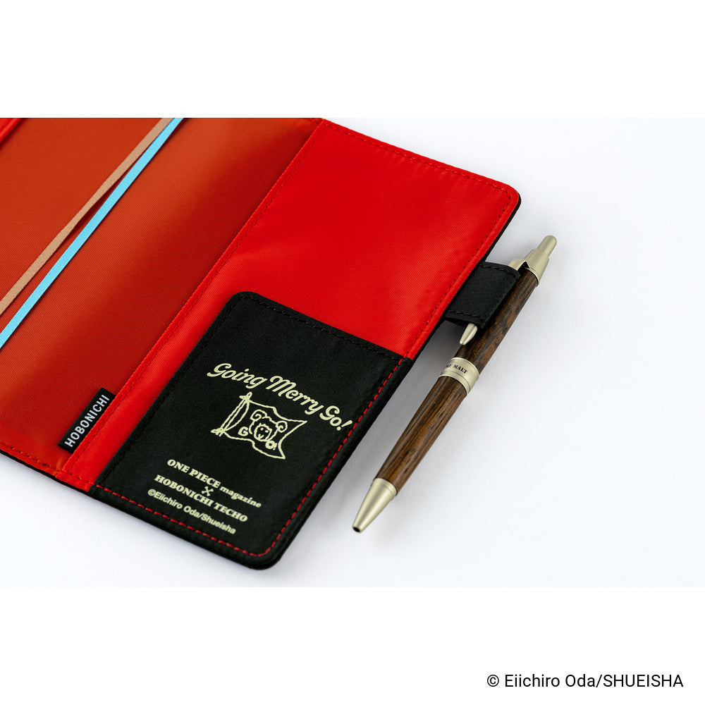Open book cover showing red interior, Black pen holder flap with Going Merry gold print, and wooden pen