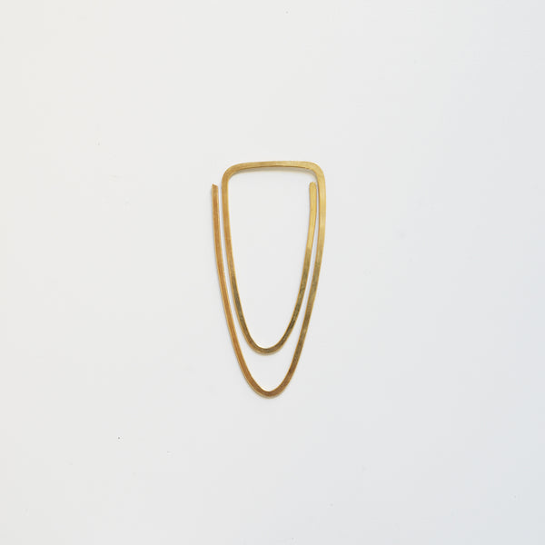 Hand-forged brass clip with a curved teardrop shape, shown flat on a white background.