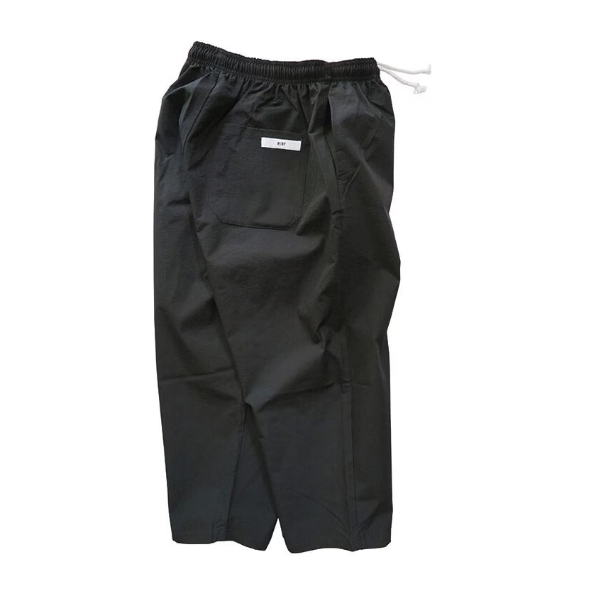 Black relaxed-fit Sunday Pants seen from the back, with elastic drawstring waist and patch back pocket.