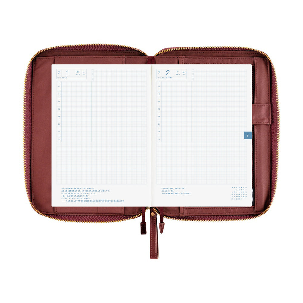 Hobonichi A5 Cousin zippered cover in Amarone, open flat to show grid daily pages and inner pockets