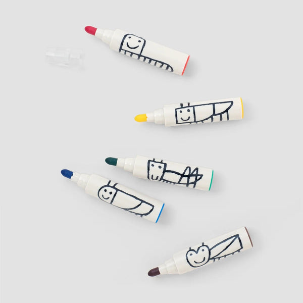 Five white Woset markers with hand-drawn bug faces, each with a different colored tip, plus a clear cap.