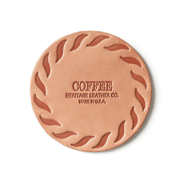 Round natural leather coaster embossed "COFFEE, Heritage Leather Co., Made in U.S.A." with swirl border.