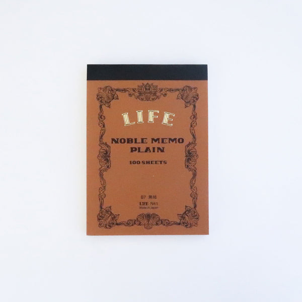 LIFE Noble Memo B7 plain memo pad with brown cover, ornate scrollwork border and black taped top edge.