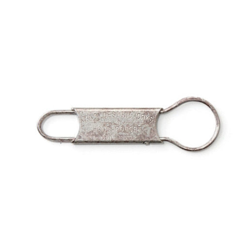 Antiqued stainless steel key ring with a loop at each end and stamped Candy Design & Works lettering.