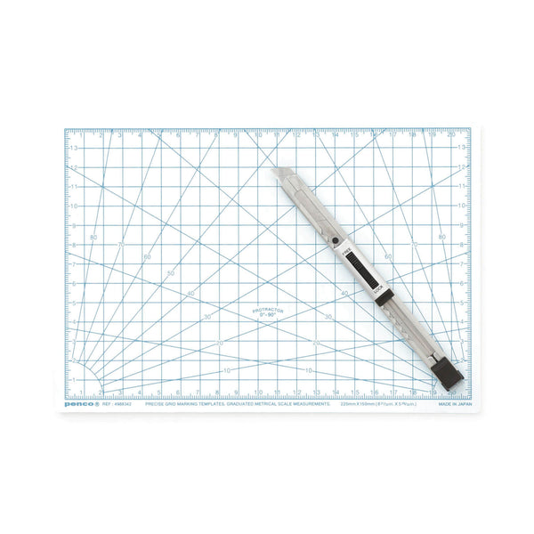 Penco A5 cutting mat in White with blue grid, scales and protractor markings, a utility knife on top.
