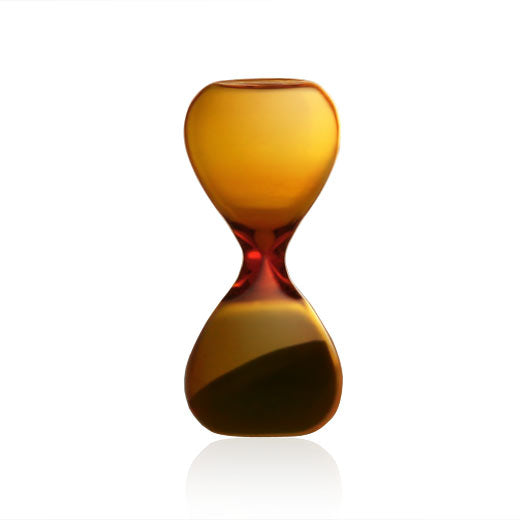 Hightide Amber glass hourglass with rounded bulbs and sand in the lower chamber, on white.