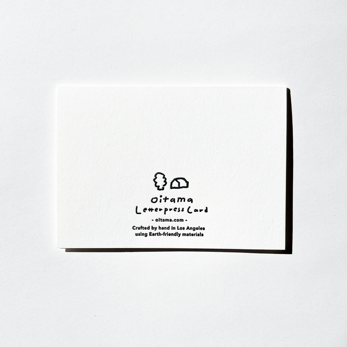 Back of a white Oitama letterpress card showing the printed logo and hand-crafted in Los Angeles text.